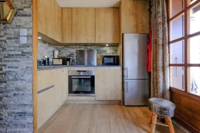 a kitchen with a refrigerator and a chair at Ali'Home vue MontBlanc - T2 de charme in Demi-Quartier
