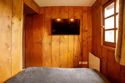 a bedroom with a bed and a television on a wall at Ali'Home vue MontBlanc - T2 de charme in Demi-Quartier