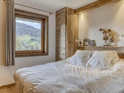 a bedroom with a large bed with a window at Appartement rénové 2 pièces, balcon, parking à Megève - FR-1-453-319 in Megève