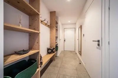 a hallway with wooden shelves and a green chair at Maira Les Carroz - by EMERALD STAY in Arâches-la-Frasse