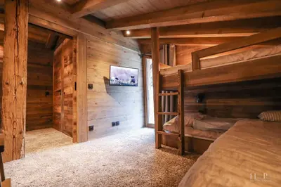 a bedroom in a log cabin with a bunk bed at Chalet du Gouter in Combloux