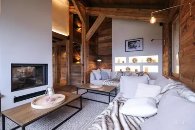 a living room with white furniture and a fireplace at Chalet du Gouter in Combloux