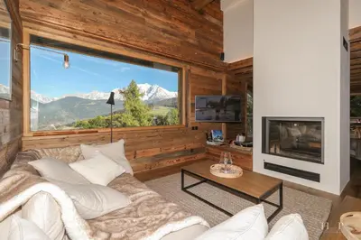 a living room with a couch and a large window at Chalet du Gouter in Combloux
