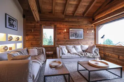 a living room with two couches and a table at Chalet du Gouter in Combloux