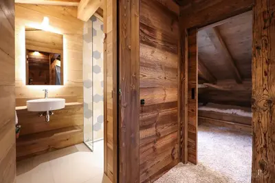 a bathroom in a log cabin with a sink and a mirror at Chalet du Gouter in Combloux