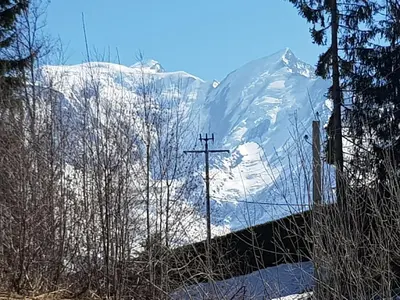 a snow covered mountain with a cross in the foreground at Chalet la Cry à St Gervais in Saint-Gervais-les-Bains