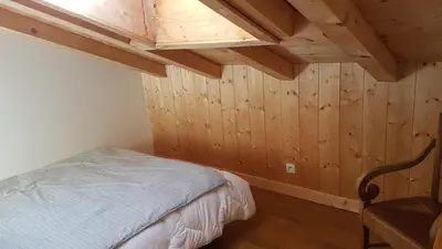 a bedroom with a bed and a wooden ceiling at Chalet la Cry à St Gervais in Saint-Gervais-les-Bains