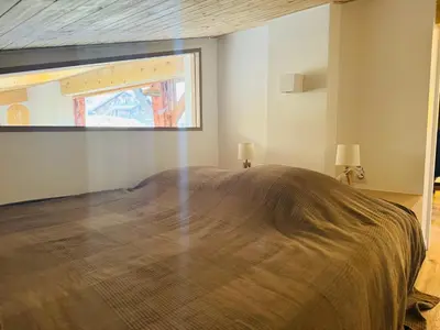 a bedroom with a large bed with a large window at Superbe appartement rénové 110m2 - 9 pers - vue montagne - Les Contamines in Les Contamines-Montjoie
