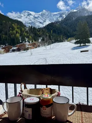 a table with two coffee cups and a view of a snowy mountain at Superbe appartement rénové 110m2 - 9 pers - vue montagne - Les Contamines in Les Contamines-Montjoie