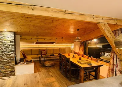 a kitchen with a table and a stone wall at Superbe appartement rénové 110m2 - 9 pers - vue montagne - Les Contamines in Les Contamines-Montjoie