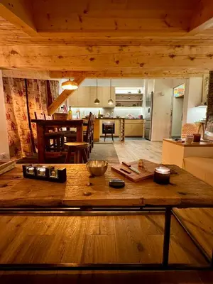 a kitchen and living room with a wooden table at Superbe appartement rénové 110m2 - 9 pers - vue montagne - Les Contamines in Les Contamines-Montjoie