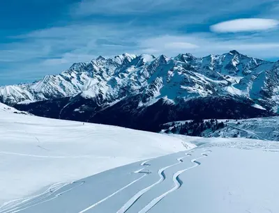 a snow covered mountain range with tracks in the snow at Superbe appartement rénové 110m2 - 9 pers - vue montagne - Les Contamines in Les Contamines-Montjoie
