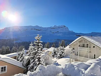 a house covered in snow with a mountain in the background at Les Chalets de Flaine Hameau - maeva Home - Chalet 4 pièces 6 personnes - Prestige MAE-3971 in Flaine