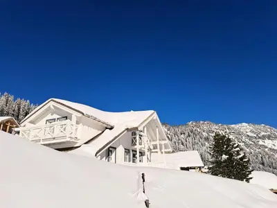a person skiing down a snow covered slope in front of a house at Les Chalets de Flaine Hameau - maeva Home - Chalet 4 pièces 6 personnes - Prestige MAE-3971 in Flaine