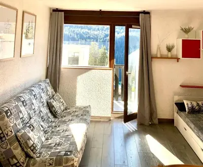 a living room with a couch and a large window at Studio Flaine à coté des pistes in Arâches-la-Frasse
