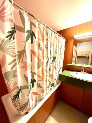 a bathroom with a sink and a shower curtain at Studio Flaine à coté des pistes in Arâches-la-Frasse