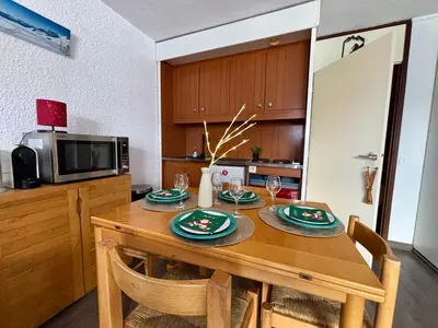 a kitchen with a wooden table with plates on it at Studio Flaine à coté des pistes in Arâches-la-Frasse