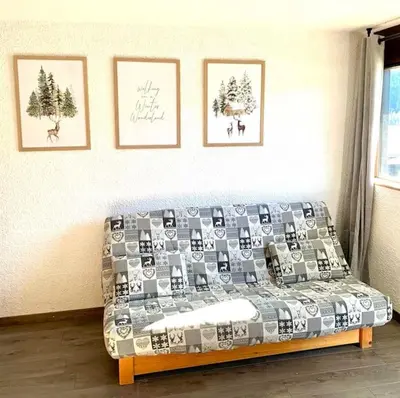 a living room with a couch and pictures on the wall at Studio Flaine à coté des pistes in Arâches-la-Frasse