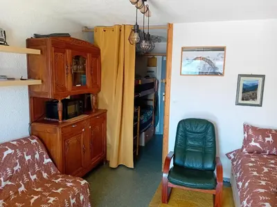 a living room with a couch a chair and a cabinet at Ski1600 - GrandMassif in Samoëns