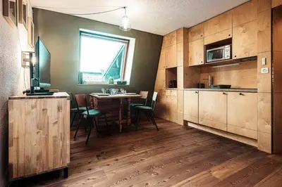 a kitchen with wooden cabinets and a table with chairs at Vertice - Center Chamonix Mont-Blanc View in Chamonix-Mont-Blanc
