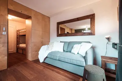 a living room with a blue couch and a mirror at Vertice - Center Chamonix Mont-Blanc View in Chamonix-Mont-Blanc