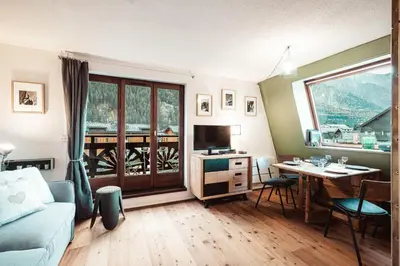 a living room with a couch and a table with a television at Vertice - Center Chamonix Mont-Blanc View in Chamonix-Mont-Blanc