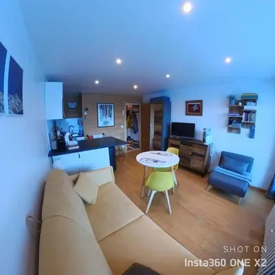 a living room with a couch and a table at Les montagnes sur le balcon in Chamonix-Mont-Blanc