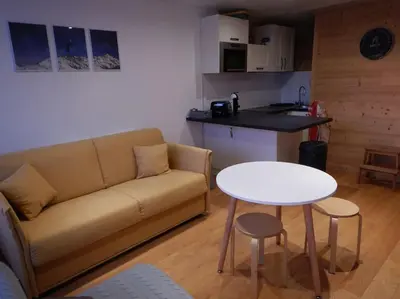 a living room with a couch and a table at Les montagnes sur le balcon in Chamonix-Mont-Blanc