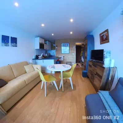 a living room with a couch and a table at Les montagnes sur le balcon in Chamonix-Mont-Blanc