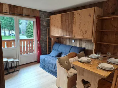 a living room with a blue couch and a table at Appartement équipé centre Carroz et garage in Arâches-la-Frasse