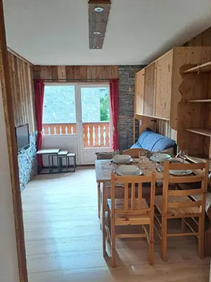 a living room with a table and a dining room at Appartement équipé centre Carroz et garage in Arâches-la-Frasse