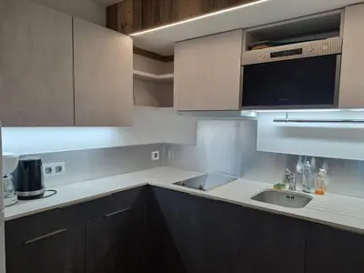 a kitchen with brown cabinets and a sink at Appartement équipé centre Carroz et garage in Arâches-la-Frasse