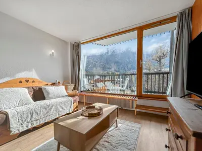 a bedroom with a bed and a large window at Vue Mont Blanc, balcon et parking privé in Chamonix-Mont-Blanc