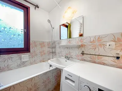 a bathroom with a sink and a tub and a mirror at Vue Mont Blanc, balcon et parking privé in Chamonix-Mont-Blanc