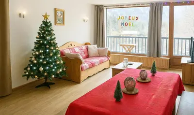 a living room with a christmas tree in it at Vue Mont Blanc, balcon et parking privé in Chamonix-Mont-Blanc