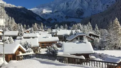 a village covered in snow with mountains in the background at Vue Mont Blanc, balcon et parking privé in Chamonix-Mont-Blanc