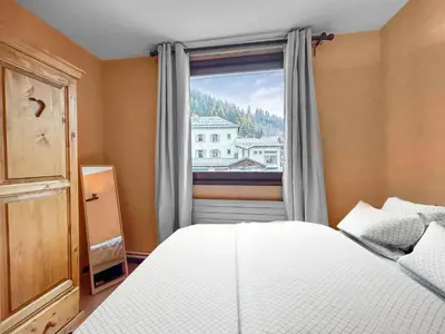 a bedroom with a bed and a window at Vue Mont Blanc, balcon et parking privé in Chamonix-Mont-Blanc