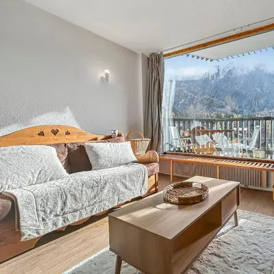 a bedroom with a bed and a large window at Vue Mont Blanc, balcon et parking privé in Chamonix-Mont-Blanc