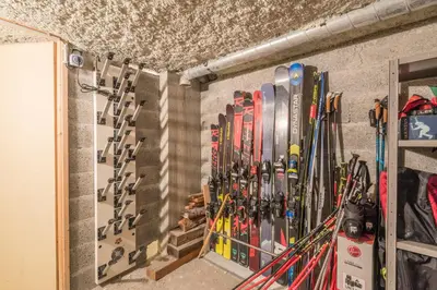 a bunch of skis are lined up against a wall at Appartement Sérénité - Welkeys in Chamonix-Mont-Blanc