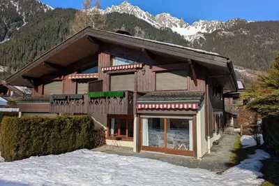 a house in the mountains with snow on the ground at Appartement Sérénité - Welkeys in Chamonix-Mont-Blanc