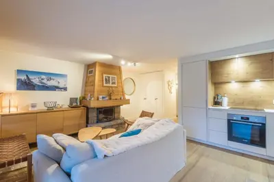 a living room with a couch and a kitchen at Appartement Sérénité - Welkeys in Chamonix-Mont-Blanc