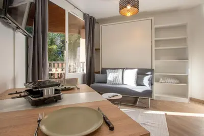 a living room with a table and a couch at Lachenal - Centre - Navette de ski - Balcon in Chamonix-Mont-Blanc