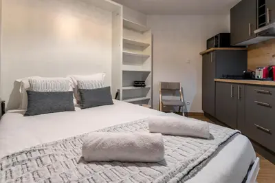 a bedroom with a large white bed with gray pillows at Lachenal - Centre - Navette de ski - Balcon in Chamonix-Mont-Blanc