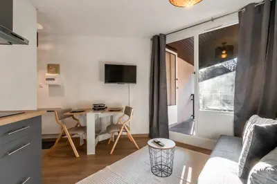 a kitchen and living room with a table and chairs at Lachenal - Centre - Navette de ski - Balcon in Chamonix-Mont-Blanc
