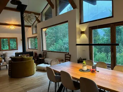 a living room with a large wooden table and chairs at Chalet des Eaux Rousses -Renove -Prive - Vues 360 Mont Blanc in Les Houches