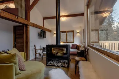 a living room with a fireplace in a house at Chalet des Eaux Rousses -Renove -Prive - Vues 360 Mont Blanc in Les Houches