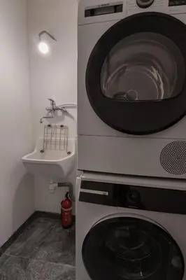 a kitchen with a washing machine and a sink at Chalet des Eaux Rousses -Renove -Prive - Vues 360 Mont Blanc in Les Houches