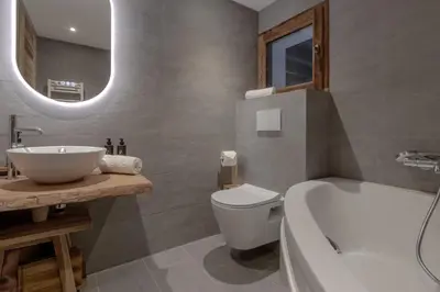 a bathroom with a tub and a sink and a toilet at Chalet des Eaux Rousses -Renove -Prive - Vues 360 Mont Blanc in Les Houches