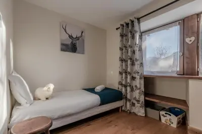 a small bedroom with a bed and a window at La Ferme du Mont in Servoz
