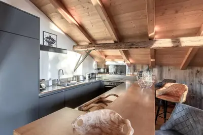 a kitchen with a wooden ceiling and a wooden table at La Ferme du Mont in Servoz